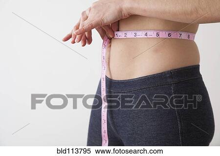 Caucasian woman measuring her waistline View Large Photo Image Stock Photography - Caucasian woman measuring her waistline. Fotosearch
