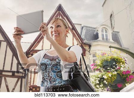 Caucasian woman taking pictures with tablet computer View Large Photo Image Stock Image - Caucasian woman taking pictures with tablet computer. Fotosearch