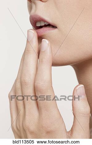 Stock Photography - Caucasian woman touching her lip. Fotosearch