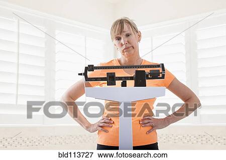 Caucasian woman weighing herself View Large Photo Image Stock Photo - Caucasian woman weighing herself. Fotosearch