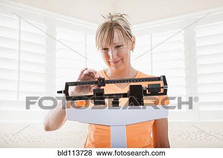 Caucasian woman weighing herself View Large Photo Image Stock Photo - Caucasian woman weighing herself. Fotosearch