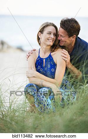 Couple smiling together on beach View Large Photo Image Stock Image - Couple smiling together on beach. Fotosearch
