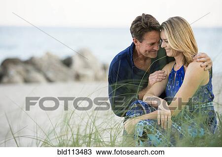 Stock Image - Couple smiling together on beach. Fotosearch