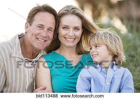 Stock Photo - Family hugging outdoors. Fotosearch