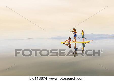 Family riding paddle boards View Large Photo Image Picture - Family riding paddle boards. Fotosearch