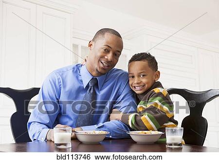 Stock Photograph - Father and son having breakfast together. Fotosearch