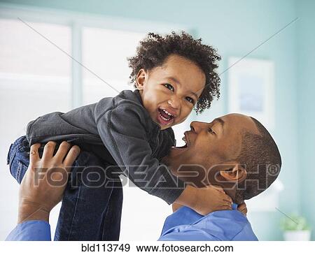 Stock Photo - Father and son playing indoors. Fotosearch