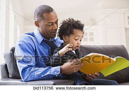 Father and son reading on sofa View Large Photo Image Stock Photograph - Father and son reading on sofa. Fotosearch