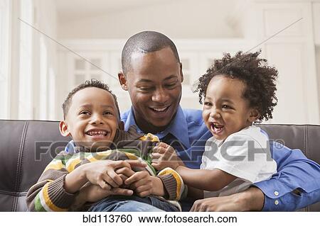 Father and sons relaxing on sofa View Large Photo Image Stock Image - Father and sons relaxing on sofa. Fotosearch