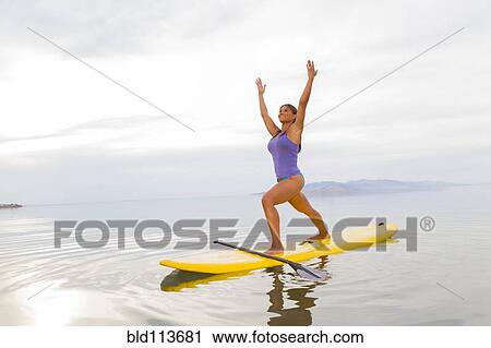Filipino woman practicing yoga on paddle board View Large Photo Image Stock Image - Filipino woman practicing yoga on paddle board. Fotosearch