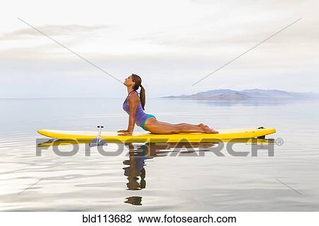 Filipino woman practicing yoga on paddle board View Large Photo Image Stock Image - Filipino woman practicing yoga on paddle board. Fotosearch