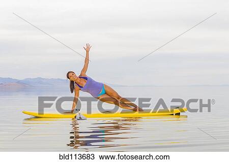 Filipino woman practicing yoga on paddle board View Large Photo Image Stock Image - Filipino woman practicing yoga on paddle board. Fotosearch