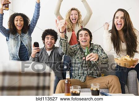 Stock Photo - Friends cheering in living room. Fotosearch