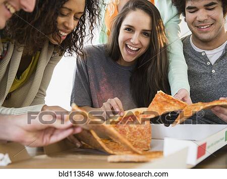 Stock Photo - Friends having pizza together. Fotosearch