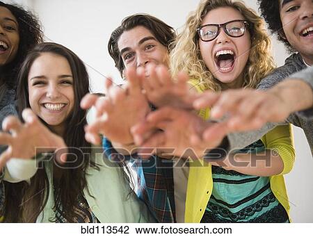 Stock Image - Friends reaching out together. Fotosearch