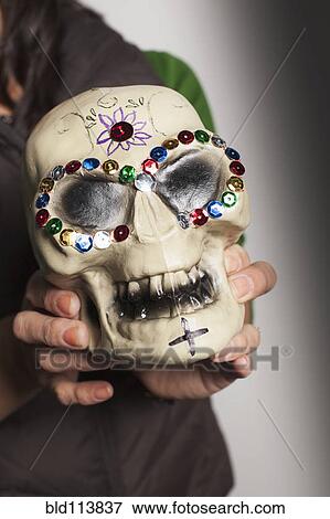 Hispanic artist holding Dia de los Muertos skull View Large Photo Image Stock Photo - Hispanic artist holding Dia de los Muertos skull. Fotosearch