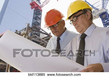 Stock Photography - Hispanic businessmen reading blueprints. Fotosearch