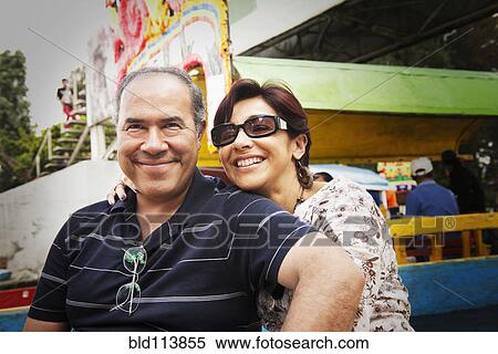 Stock Photography - Hispanic couple smiling at amusement park. Fotosearch