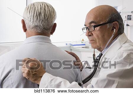 Hispanic doctor examining patient View Large Photo Image Stock Photograph - Hispanic doctor examining patient. Fotosearch