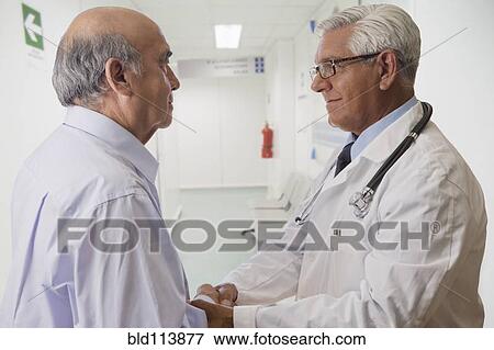 Stock Photo - Hispanic doctor talking with patient. Fotosearch