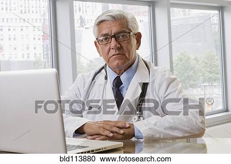 Hispanic doctor using laptop in office View Large Photo Image Stock Image - Hispanic doctor using laptop in office. Fotosearch