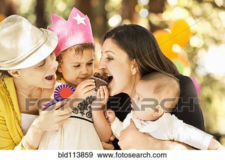 Stock Photo - Hispanic family sharing cupcake. Fotosearch