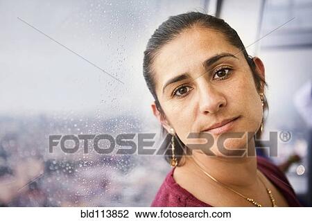 Stock Image - Hispanic woman riding elevator. Fotosearch