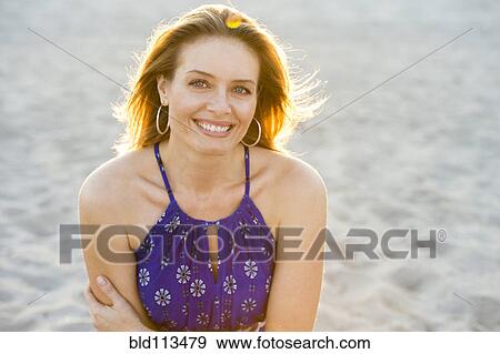 Stock Photo - Hispanic woman smiling on beach. Fotosearch
