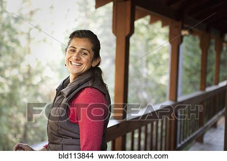 Hispanic woman smiling on porch View Large Photo Image Picture - Hispanic woman smiling on porch. Fotosearch