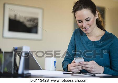 Stock Photo - Hispanic woman using cell phone. Fotosearch