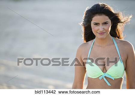Stock Image - Hispanic woman wearing bikini in water. Fotosearch