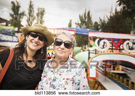 Hispanic women smiling at amusement park View Large Photo Image Stock Photograph - Hispanic women smiling at amusement park. Fotosearch