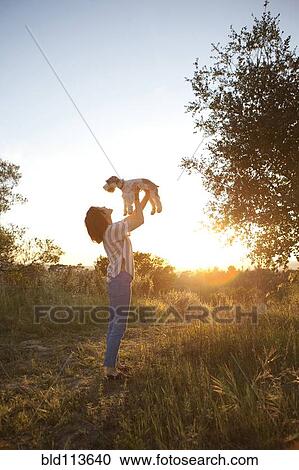 Korean woman playing with dog in meadow View Large Photo Image Stock Image - Korean woman playing with dog in meadow. Fotosearch