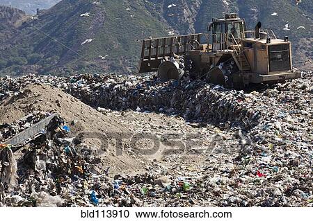 Stock Image - Machinery working in landfill. Fotosearch