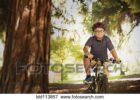 Mixed race boy riding mountain bike in forest View Large Photo Image Stock Photo - Mixed race boy riding mountain bike in forest. Fotosearch