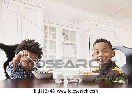 Mixed race boys eating at table View Large Photo Image Stock Image - Mixed race boys eating at table. Fotosearch