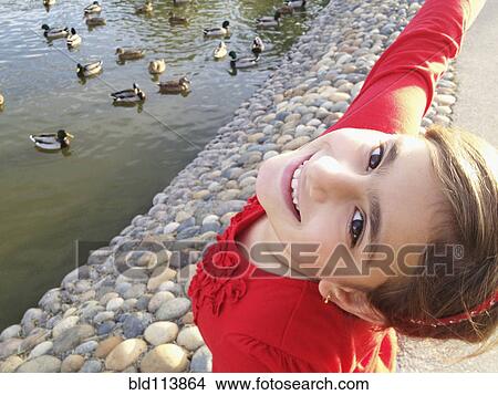 Picture - Mixed race girl smiling by river. Fotosearch