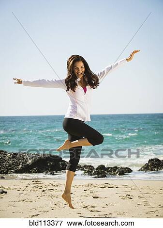 Mixed race woman jumping for joy on beach View Large Photo Image Stock Photo - Mixed race woman jumping for joy on beach. Fotosearch
