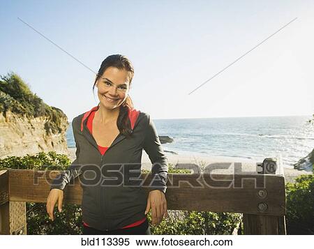 Stock Photography - Mixed race woman smiling by beach. Fotosearch