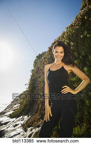 Mixed race woman smiling on rocky beach View Large Photo Image Stock Photography - Mixed race woman smiling on rocky beach. Fotosearch