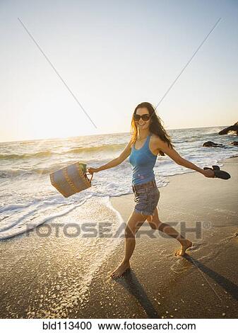 Mixed race woman walking on beach View Large Photo Image Stock Image - Mixed race woman walking on beach. Fotosearch