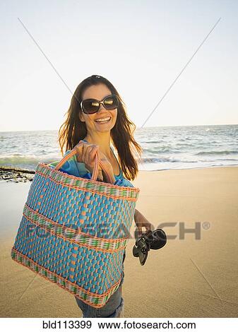 Stock Photo - Mixed race woman walking on beach. Fotosearch