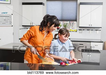 Stock Photo - Mother and daughter cooking together. Fotosearch