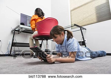 Mother and daughter using technology in home office View Large Photo Image Stock Photo - Mother and daughter using technology in home office. Fotosearch
