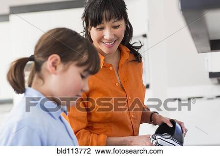 Mother and daughter washing dishes in kitchen View Large Photo Image Stock Image - Mother and daughter washing dishes in kitchen. Fotosearch