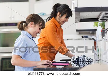 Mother and daughter washing dishes in kitchen View Large Photo Image Stock Image - Mother and daughter washing dishes in kitchen. Fotosearch