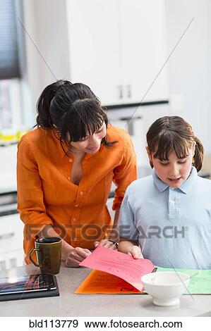 Stock Photo - Mother helping daughter with homework. Fotosearch