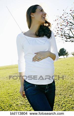 Pregnant mixed race woman holding her belly View Large Photo Image Picture - Pregnant mixed race woman holding her belly. Fotosearch