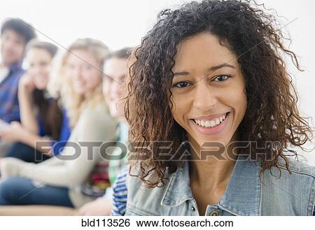 Smiling woman sitting on sofa View Large Photo Image Stock Photograph - Smiling woman sitting on sofa. Fotosearch