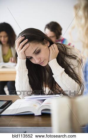Stock Image - Student reading in class. Fotosearch